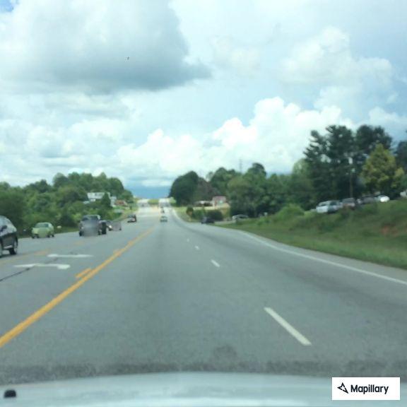 Red sedan stopped in middle of northbound lanes