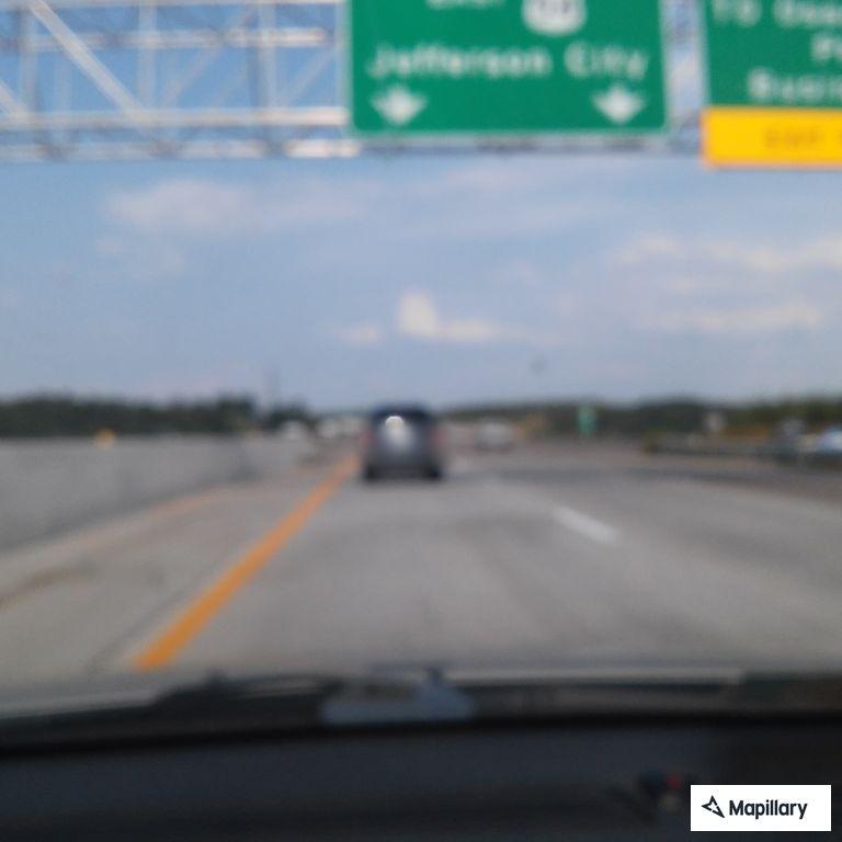 Driver changing tire with boat trailer on highway