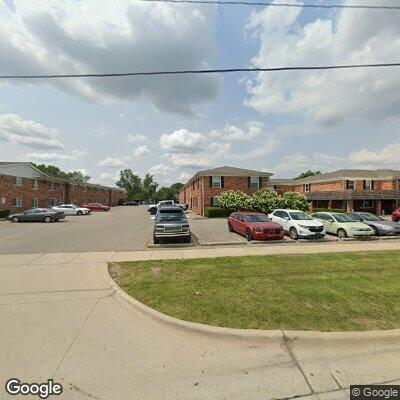 Man hanging from roof looking into apartment window