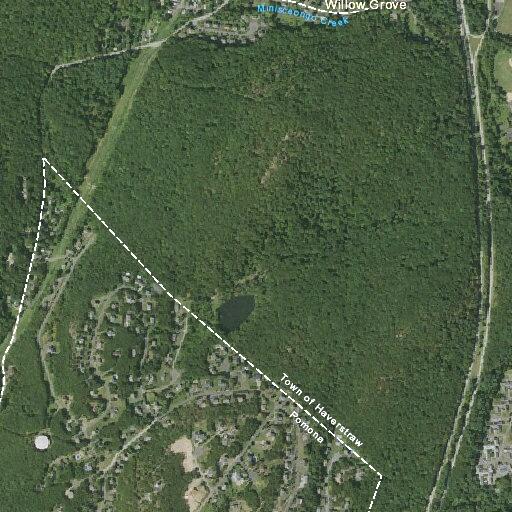 Unoccupied blue sedan left on trail near pond