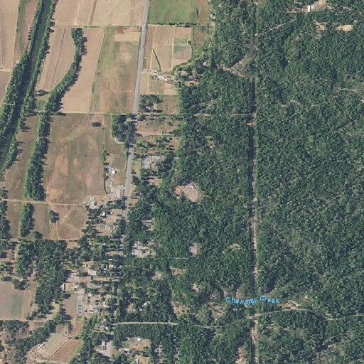 Unattended burn pile near fence on Redwood Highway