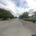 Elderly woman standing in roadway asking for money