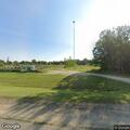Suspicious person crouching in field near cul-de-sac