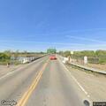 Man with flat bike tire on side of road in Butte City