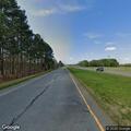 Person walking on highway shoulder near Highway 49