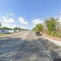 Person lying near cemetery wrestling feet on Main St
