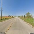 Person riding bicycle in roadway on North County Road