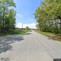 Woman walking on roadway at NC-27 near Delma Grimes Road