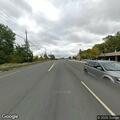 Man walking close to highway near gas station