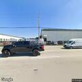 Person dumping pallets into trash behind business