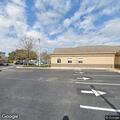 Female lying on sidewalk by bus bench at Walmart