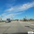 Man walking in highway traffic, throwing objects
