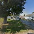 Person with backpack kneeling in neighbor’s yard