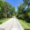 Officer checks man walking on rural roadway