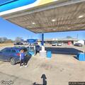 Man drinking and harming himself behind gas station