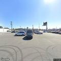 Person looking into cars with flashlight at auto lot