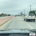 Woman flashing flashlight at roadside white car on US-80