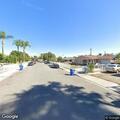 Man sharpening knife near parking lot in Pomona