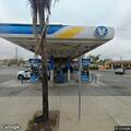 Person throwing rocks into road behind gas station