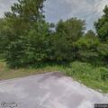 Suspicious woman hiding in trees near business