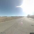 Man throwing items in road near white sports car
