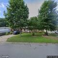 Caller reports person under carport at home