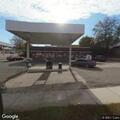 Person sleeping behind store with full cart