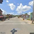 Person experiencing breathing difficulty at street intersection