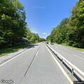 Motorcycle left on roadside with man walking nearby