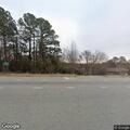 Suspicious person near abandoned home with flashlight