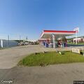 Person hides items by dumpster at Exxon station