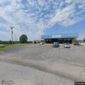 Vehicle hits truck and building at auto business