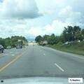 Red sedan stopped in middle of northbound lanes