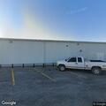 Man with open knife behind strip mall