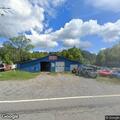 Unresponsive woman breathing at vehicle shop