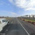 Car with flat tire on highway shoulder