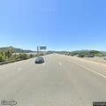 Disoriented shirtless man sitting on highway shoulder