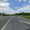 Suspicious person lying on trash bag near roadway
