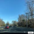 Officer checks stopped sedan in traffic lane
