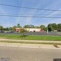 Woman sitting on sidewalk with belongings at CVS