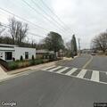 Man saluting cars while walking dog near intersection