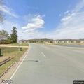 Older male falls and lies in grass at road intersection