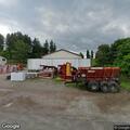 Disabled vehicle in parking lot at farm equipment shop