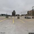 Man looking into parked vehicles on top floor