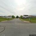 Car doing wheelies in field near subdivision