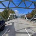 Person sitting on railing at Stillaguamish River Bridge