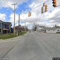 Traffic light damaged and hanging over intersection