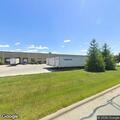 Man hitting building door with tool in parking lot