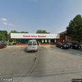 Man looking into vehicles near store on North High