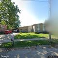 Man loitering by house in gray pickup truck